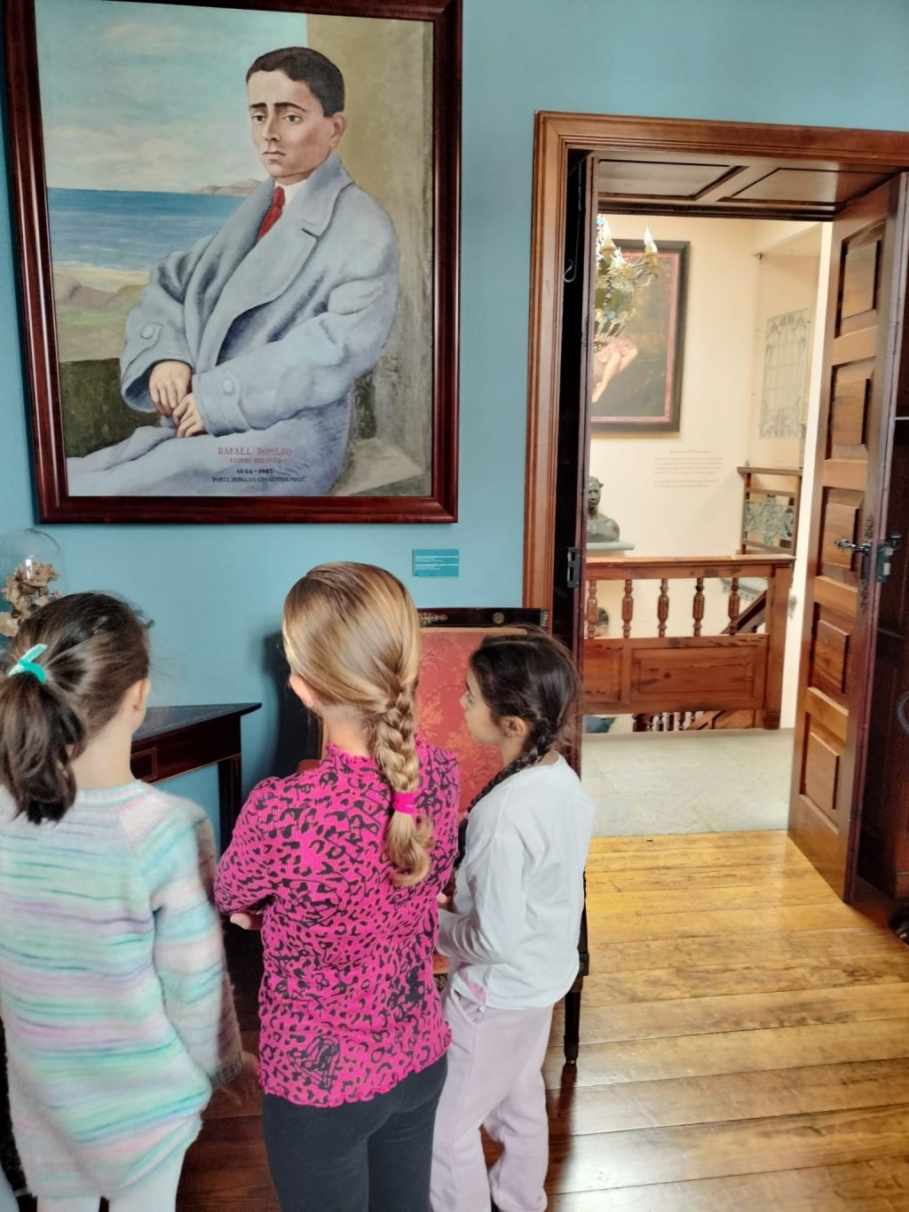 Tres niñas del taller conocen a los poetas modernistas canarios a través de sus retratos en un taller realizado las pasadas navidades.