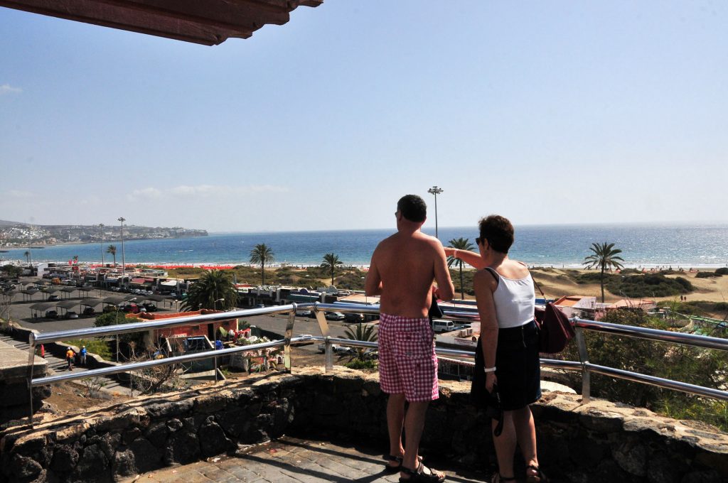 Turistas contemplan la panorámica marítima de la Playa del Inglés